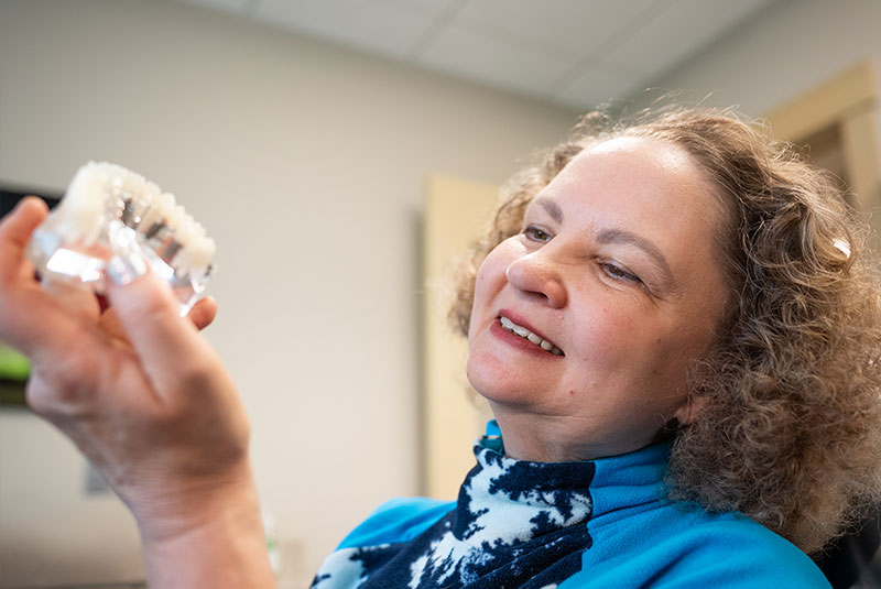 dental ipmplant patient observing full arch dental model within the dental center