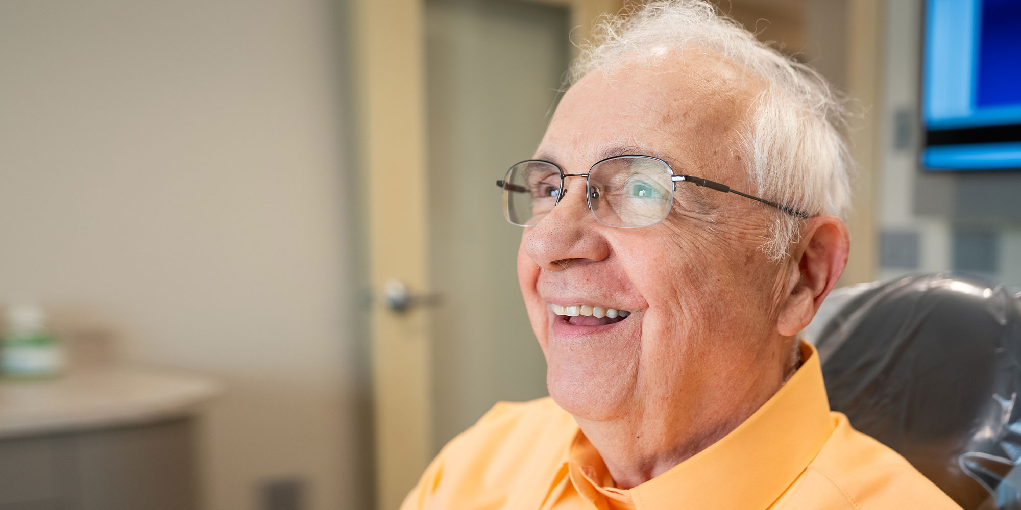 headshot of patient smiling brightly after their dental procedure