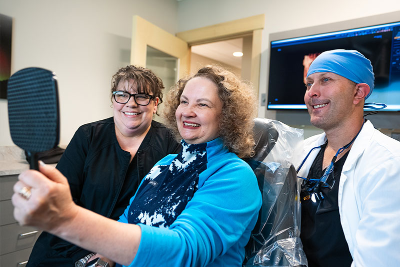 doctor and patient smiling brightly after patient's dental procedure